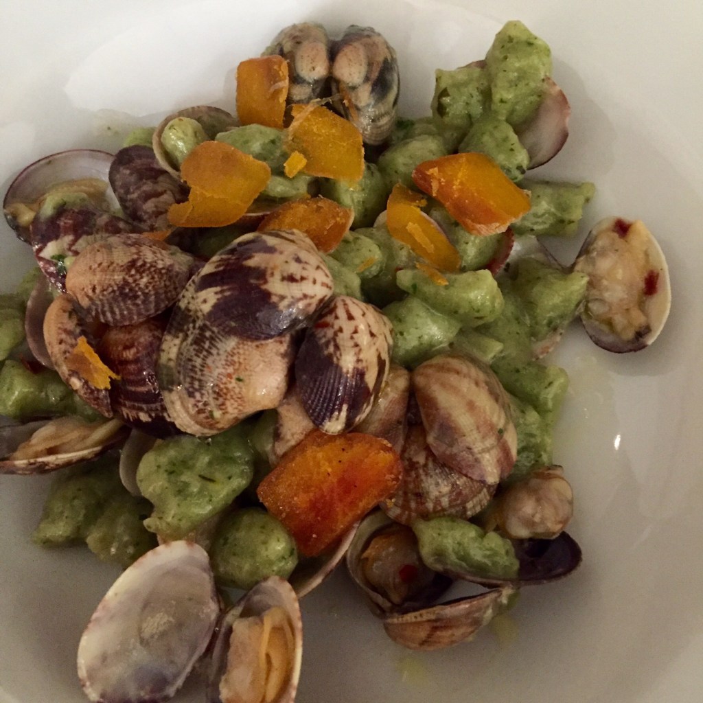Green gnocchi served with clams in the shell and cubes of squash