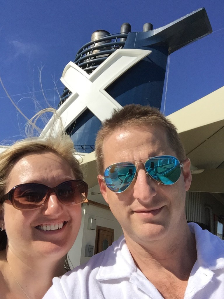 Chris and Jen on deck at Civitavecchia, the Celebrity funnel and its white X behind them