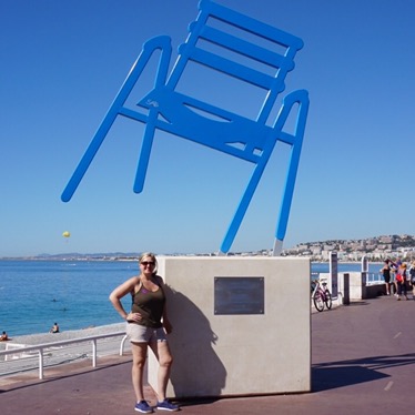 One of the oversized blue chair sculptures on the Promenade des Anglais, raised on a plinth above the sea