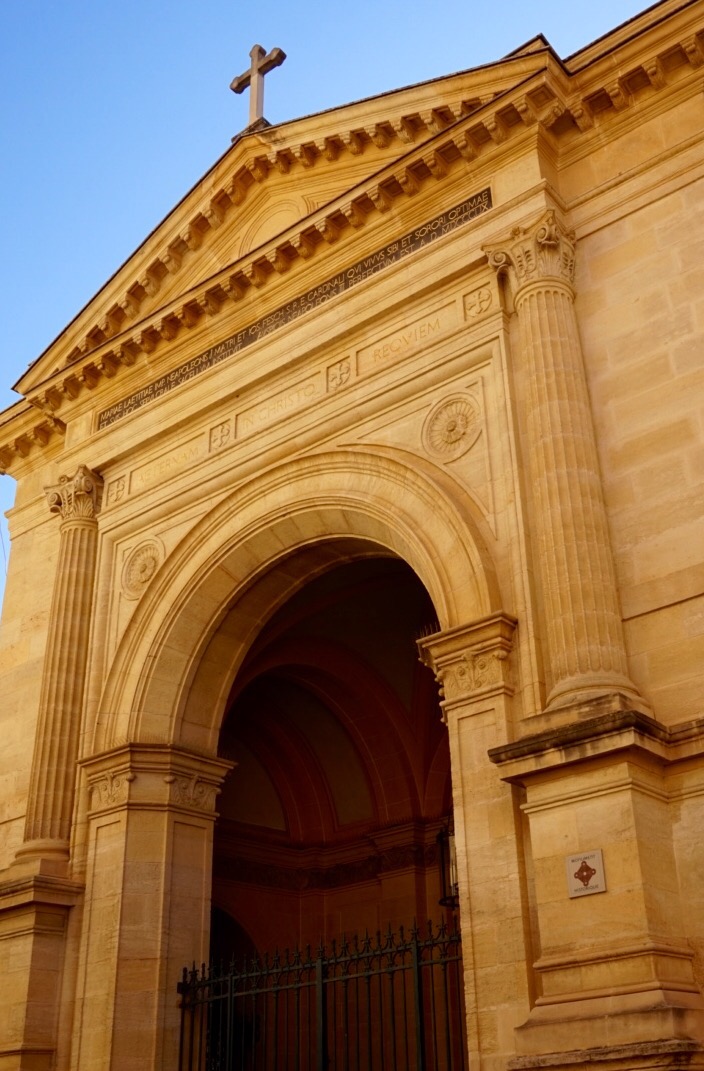 The honey-coloured stone front of Ajaccio Cathedral with its arched doorway