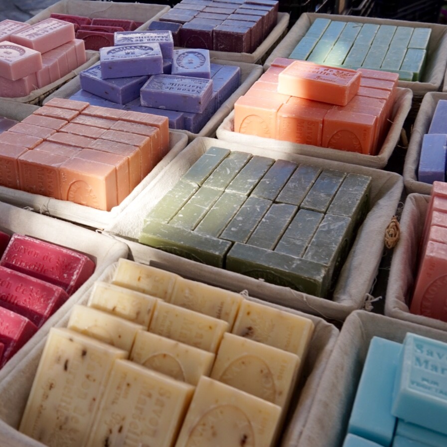 Trays of coloured soaps laid out on a market stall