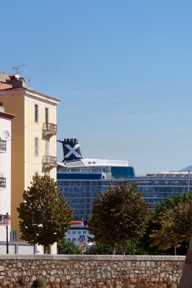 The Equinox's funnel and its white X rising above the rooftops and trees of Ajaccio