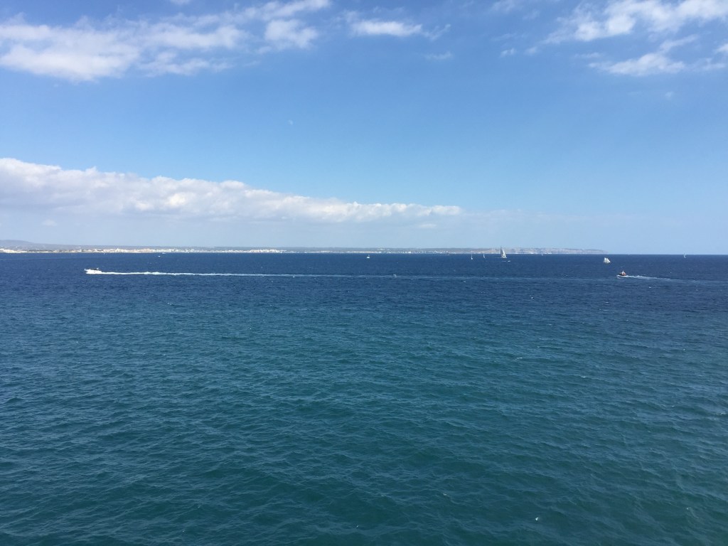 The sea from the helipad as the ship leaves Palma, the coastline low on the horizon