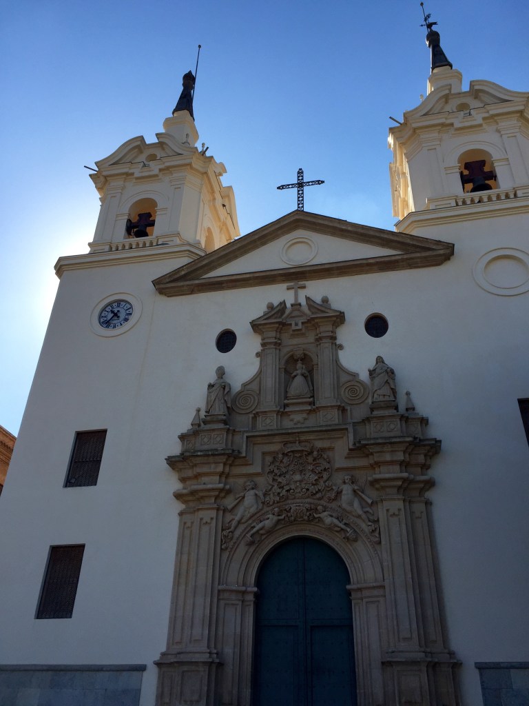The white twin-belfry front of the Fuensanta shrine with its carved stone doorway