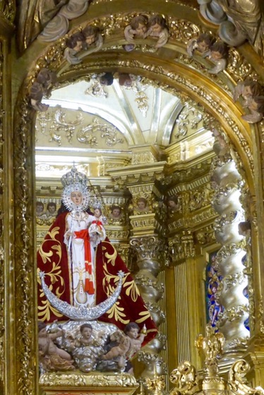 The Virgin of Fuensanta in her gilded and silvered niche, robed in red and white above a silver crescent moon