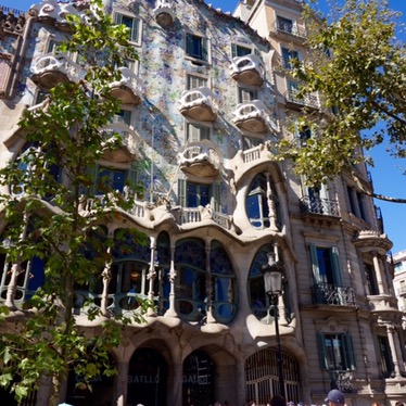The facade of Casa Batllo from the street, crowds gathered below