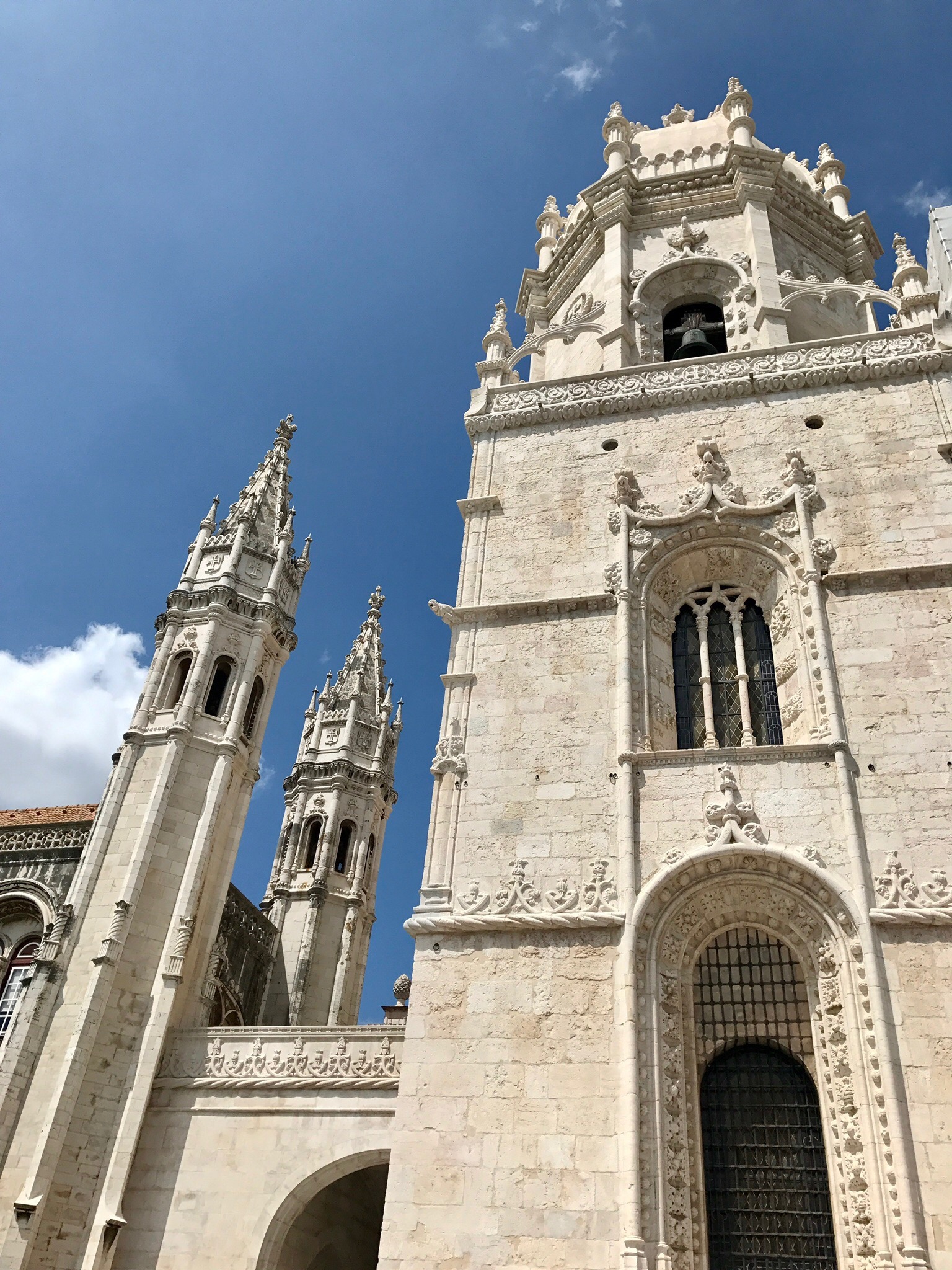 A tall Manueline limestone tower in Belém against a clear blue sky