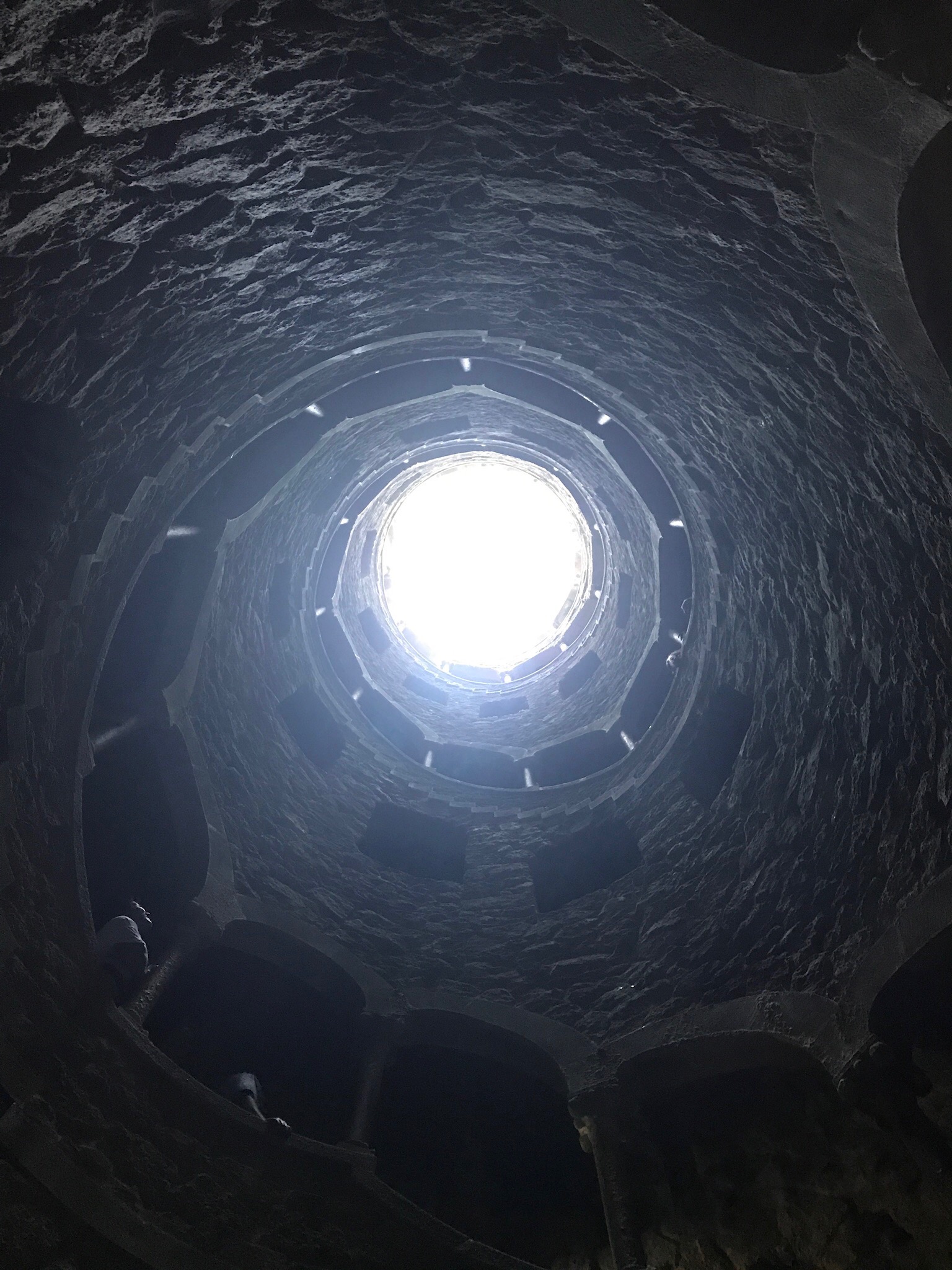 The spiral stair of the Initiation Well at Quinta da Regaleira, winding around a circle of light