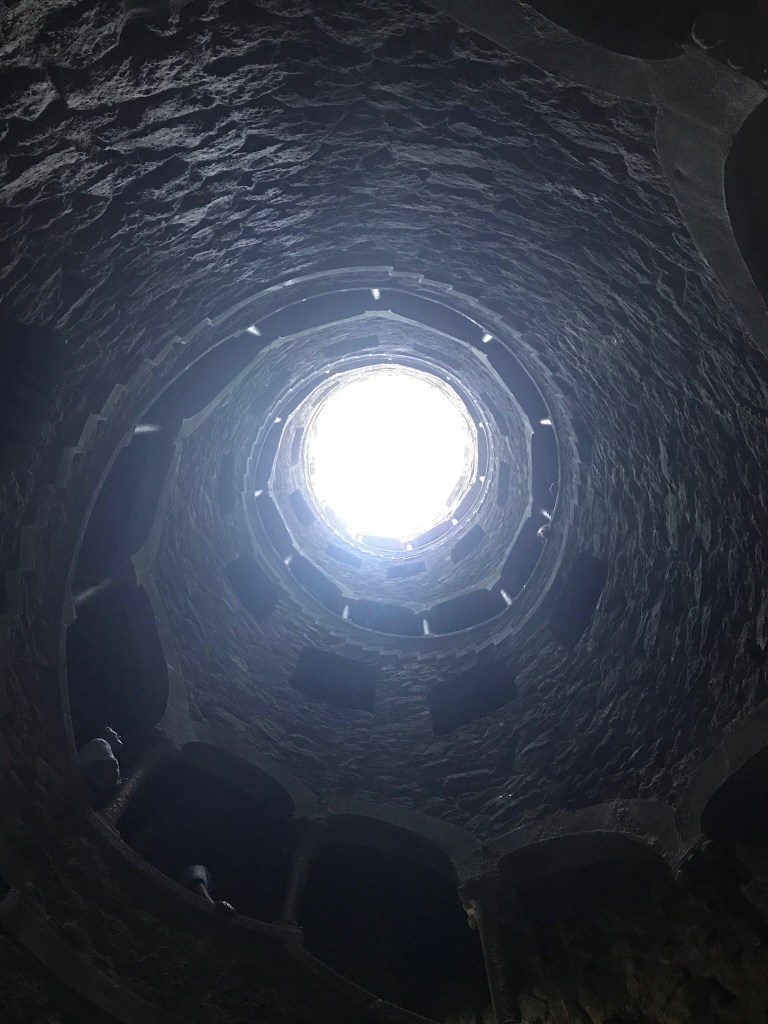 The spiral stair of the Initiation Well at Quinta da Regaleira, winding around a circle of light