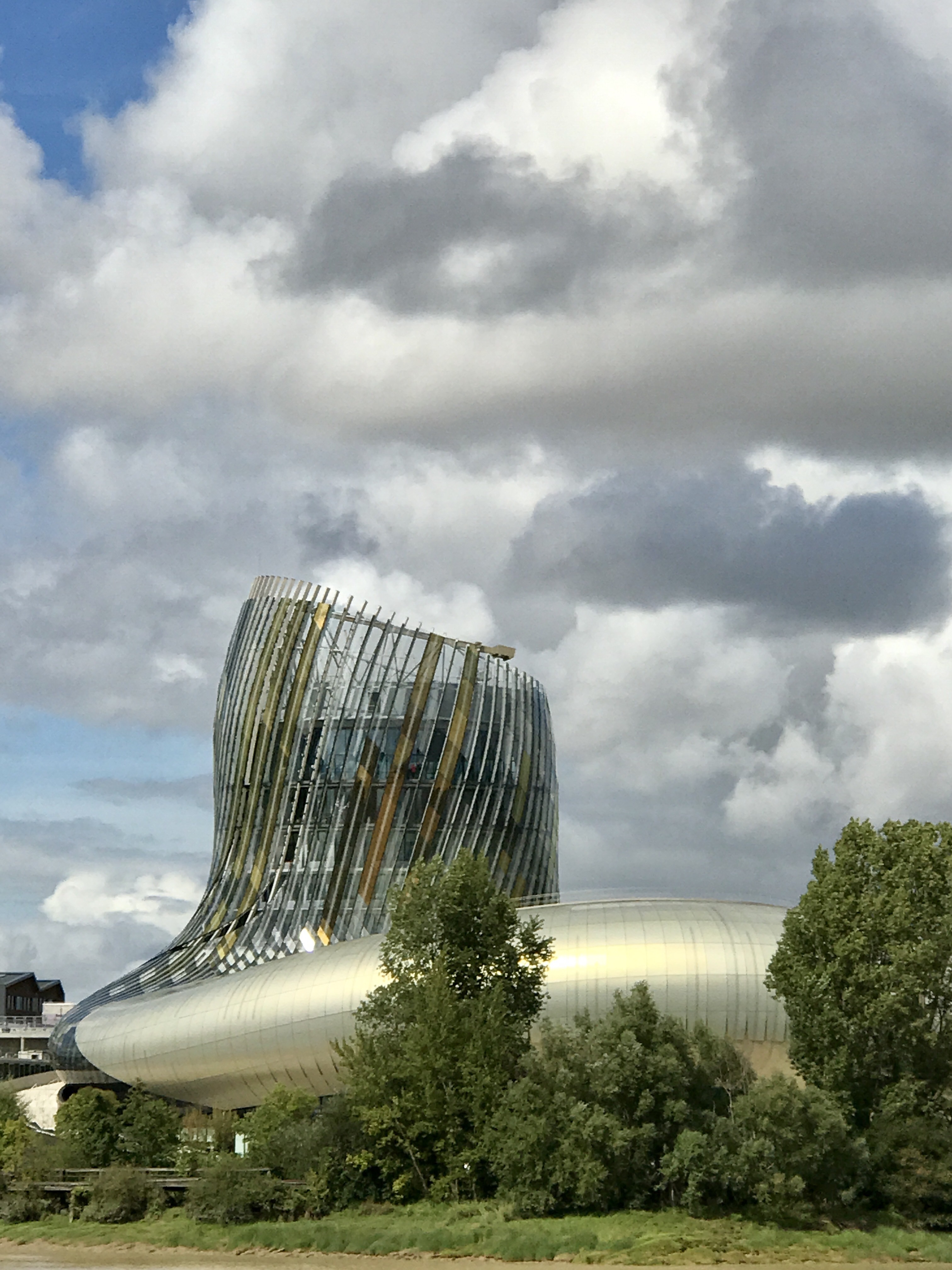 The twisting golden tower of the Cité du Vin standing on its lawn in Bordeaux