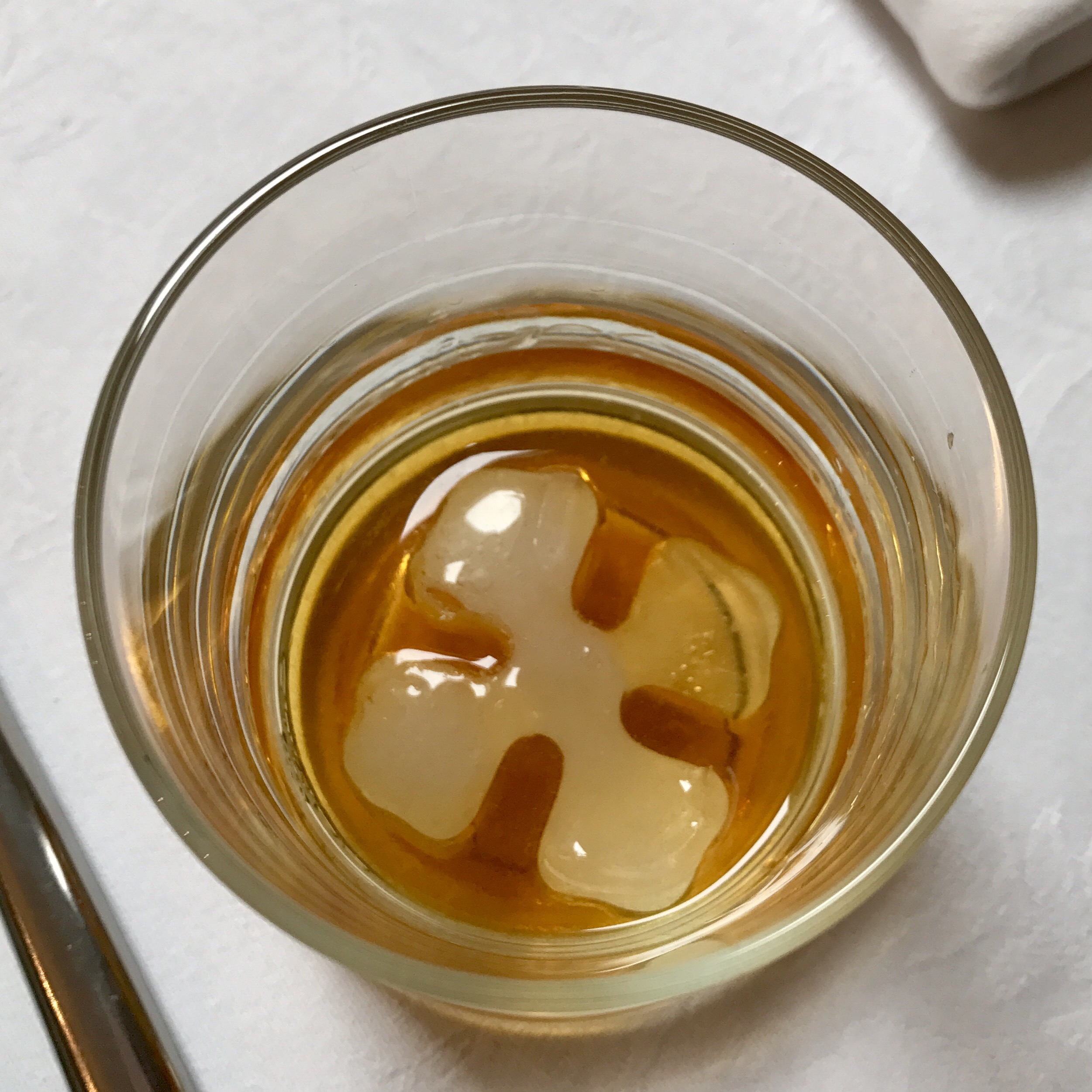 A glass of cognac over ice, seen from above