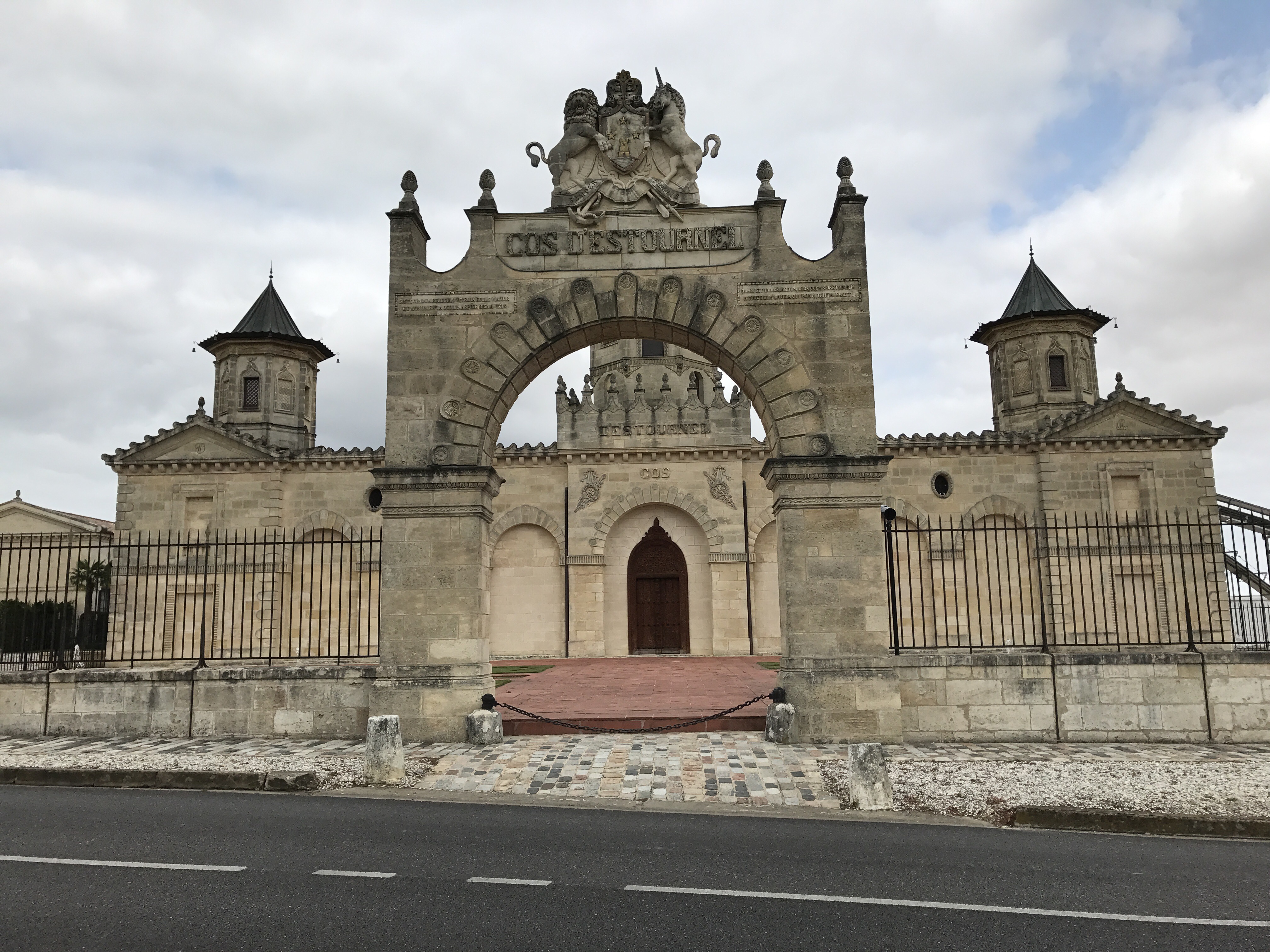 The ornate twin-towered gateway of one of the great Médoc châteaux, seen from the roadside