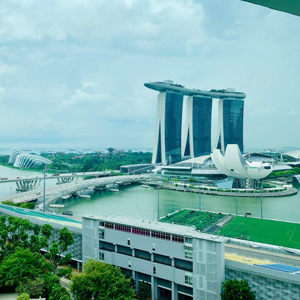 Marina Bay Sands and the Helix Bridge across the water, seen from a height on a bright afternoon