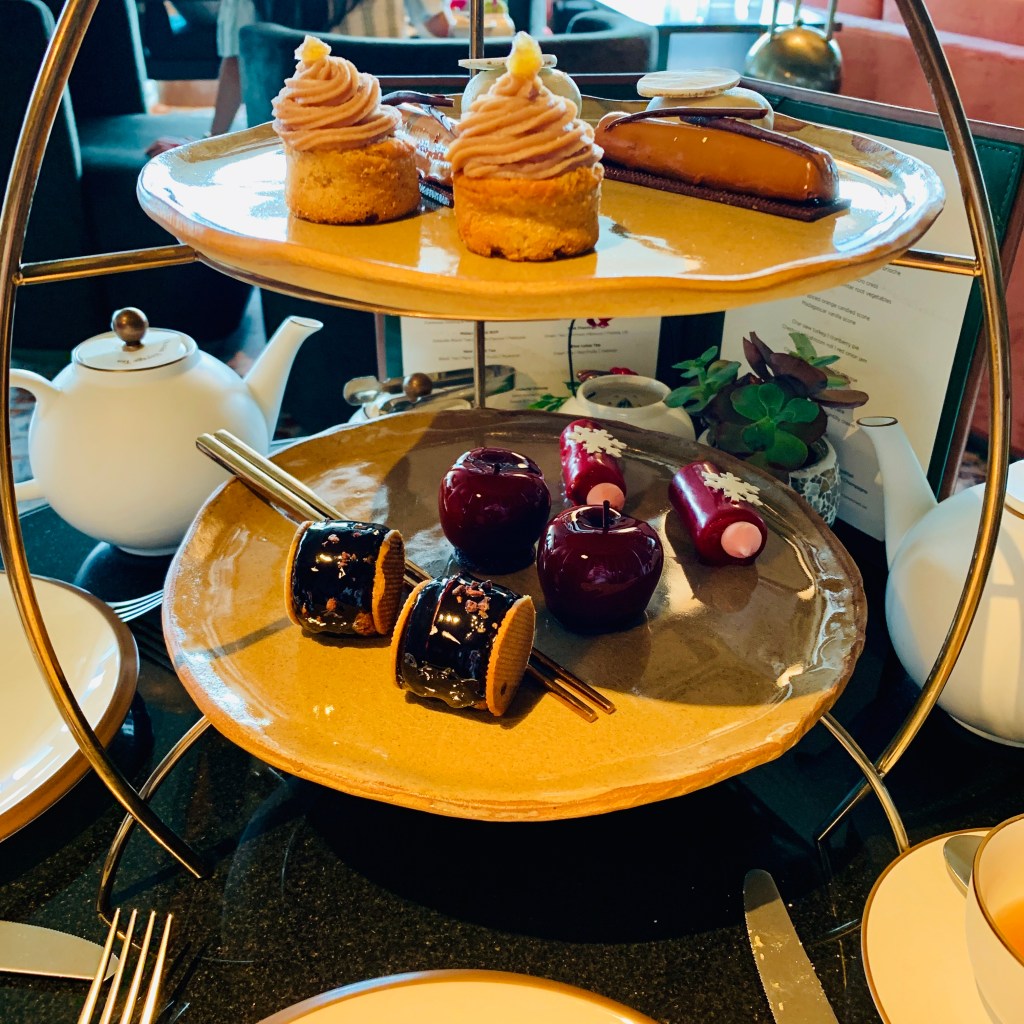 A three-tier afternoon tea stand of pastries, cakes and fruit
