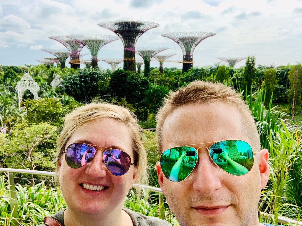 Chris and Jen in mirrored sunglasses, the Supertrees rising behind them