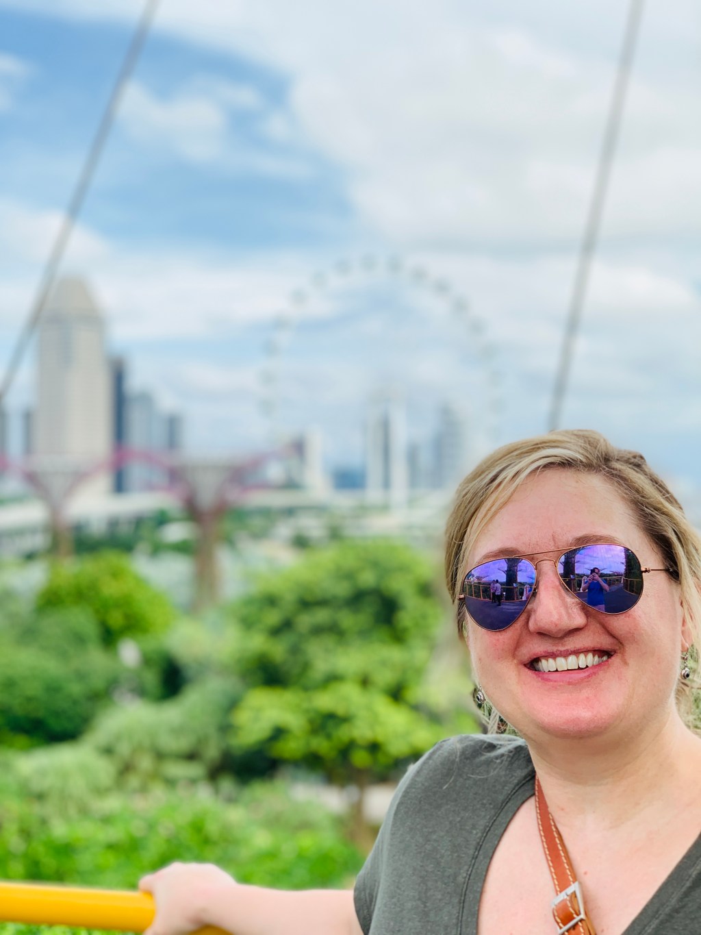 Jen in sunglasses in front of the Gardens by the Bay greenery, the city skyline behind her