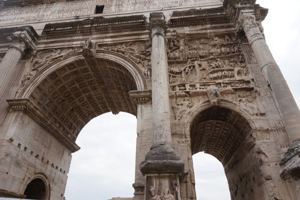 The Arch of Septimius Severus seen from beneath, its three openings and carved panels overhead