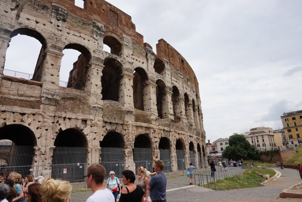 The Colosseum outer arcades seen from the street, crowds gathered along the railings