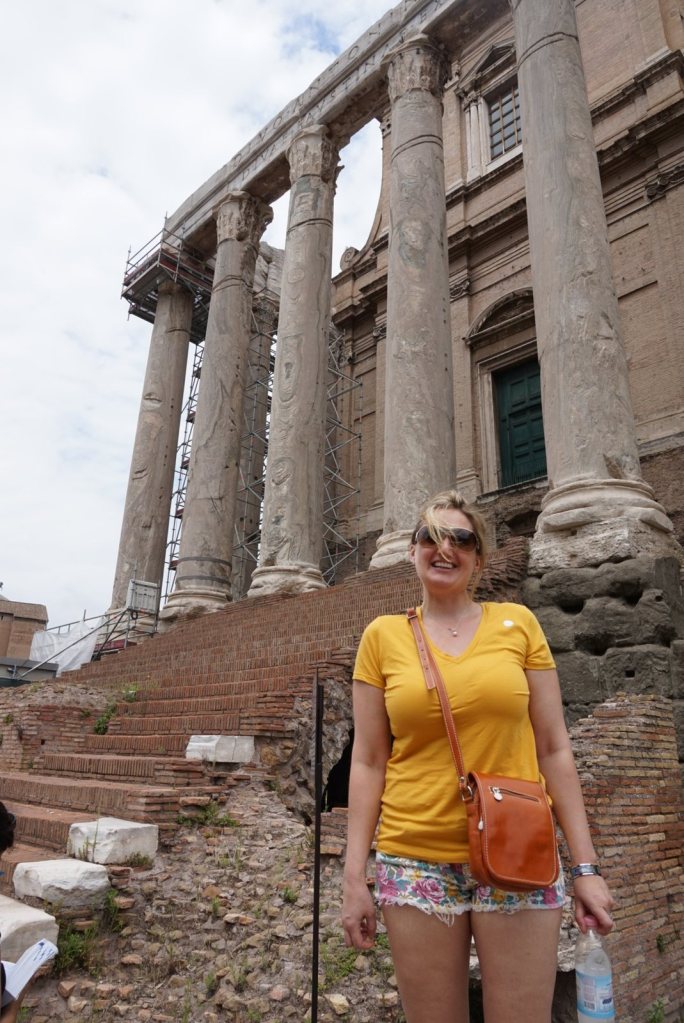 Jen on the steps below the columns of the Temple of Antoninus and Faustina