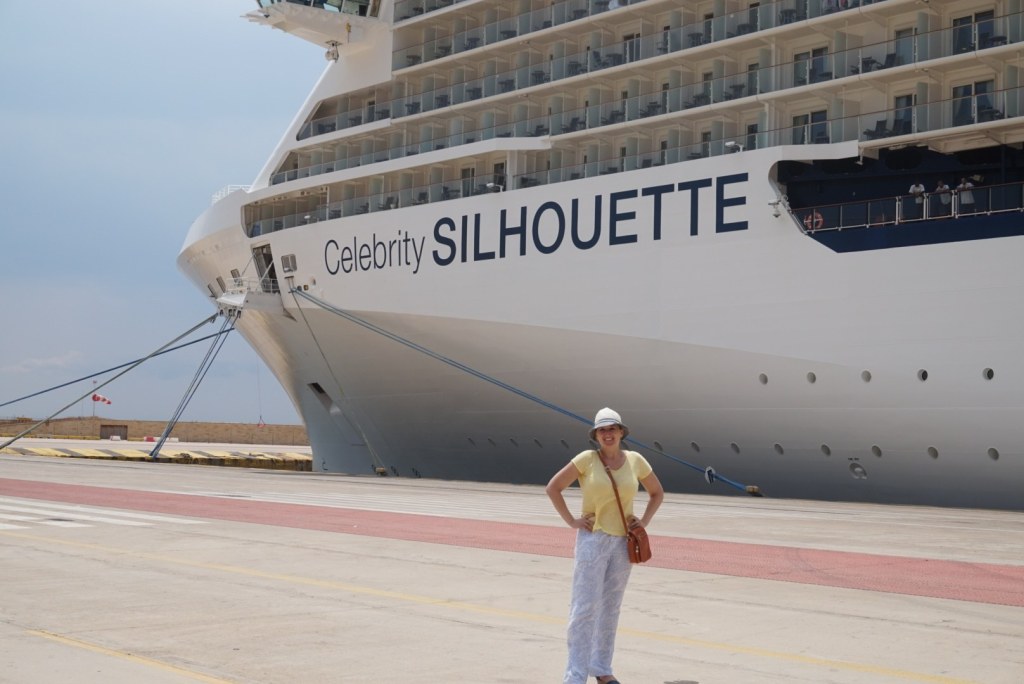Jen small in front of the Silhouette's bow on the quay at Piraeus