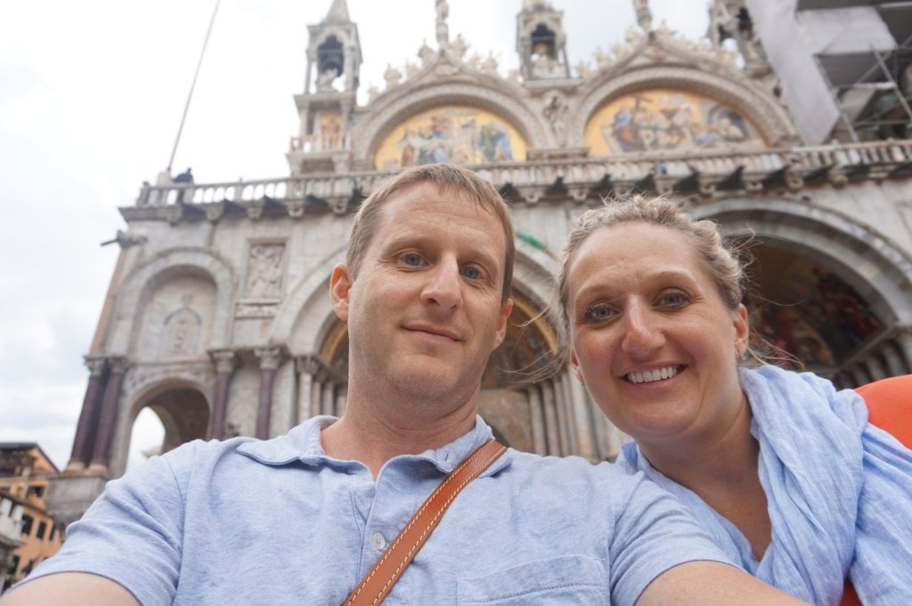 Chris and Jen in front of the mosaics and arches of St Mark's Basilica under a grey sky