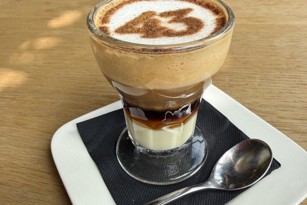 A layered café asiático in its own short glass, the number 43 stencilled in cinnamon across the foam.