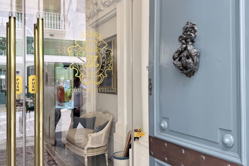 The brass doors and gold crest of the Domus Zamittello hotel on Republic Street, Valletta.