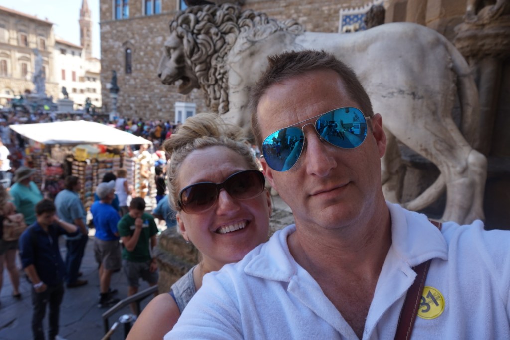 Chris and Jen in the Piazza della Signoria, the Medici lion and the sculptures of the Loggia dei Lanzi behind them